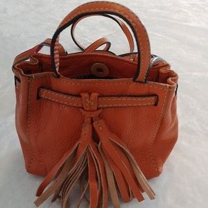 Clever Carriage Company orange mini tassel purse.
